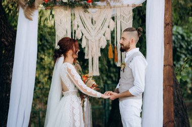 Ormandaki yeşil bir çayırda aşık genç bir çiftin düğün töreni.