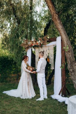 Ormandaki yeşil bir çayırda aşık genç bir çiftin düğün töreni.