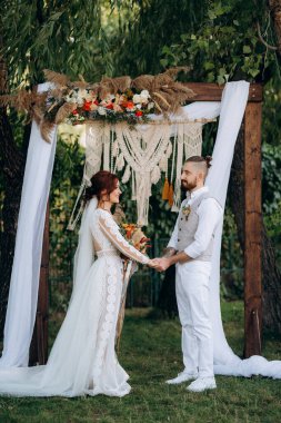 Ormandaki yeşil bir çayırda aşık genç bir çiftin düğün töreni.