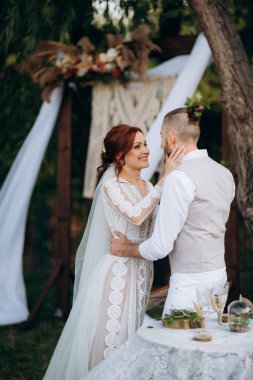 Ormandaki yeşil bir çayırda aşık genç bir çiftin düğün töreni.