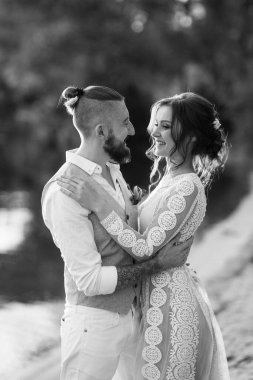 Gelin kız ve damat gün batımında nehrin kenarında