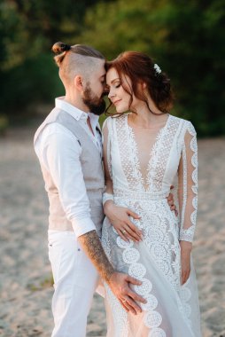 Gelin kız ve damat gün batımında nehrin kenarında