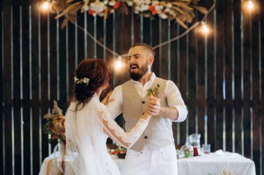 Gelin ve damadın ilk düğün dansı gün batımında restoranın içinde.