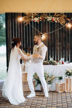 Gelin ve damadın ilk düğün dansı gün batımında restoranın içinde.