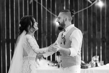 Gelin ve damadın ilk düğün dansı gün batımında restoranın içinde.