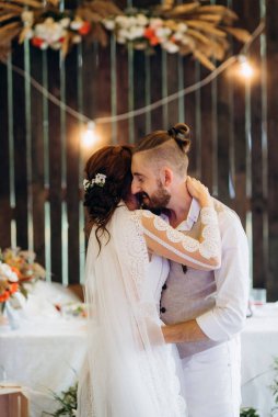 Gelin ve damadın ilk düğün dansı gün batımında restoranın içinde.