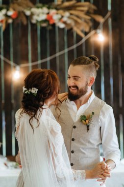 Gelin ve damadın ilk düğün dansı gün batımında restoranın içinde.