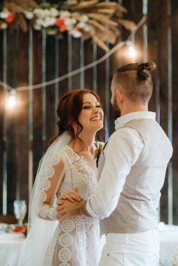 Gelin ve damadın ilk düğün dansı gün batımında restoranın içinde.