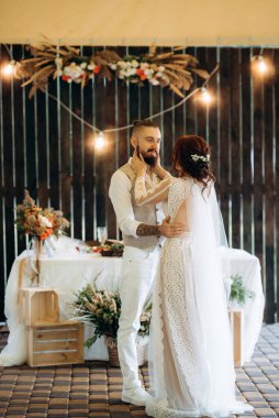Gelin ve damadın ilk düğün dansı gün batımında restoranın içinde.