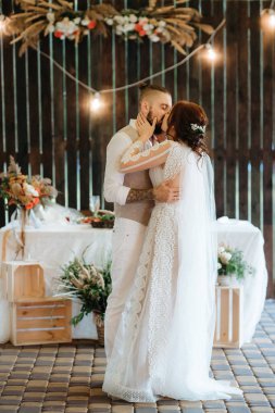 Gelin ve damadın ilk düğün dansı gün batımında restoranın içinde.