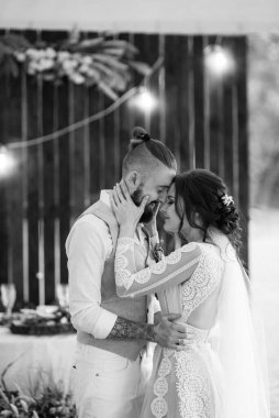 Gelin ve damadın ilk düğün dansı gün batımında restoranın içinde.