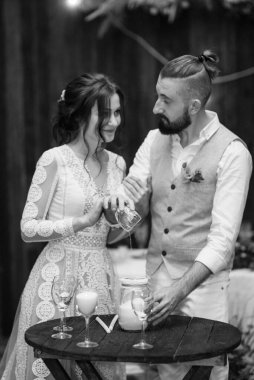 Yeni evlilerin kum seremonisi. Çok renkli kumdan bir aile mumu yaratma seremonisi.