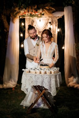newlyweds happily cut, laugh and taste the wedding cake