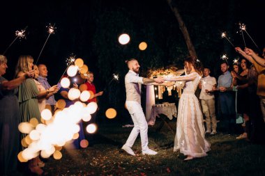 newlyweds at a wedding in the corridor of sparklers