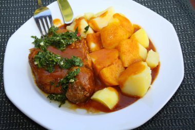 Patates, sos ve gremolata ile ossobuco, dana eti, İtalyan yemeği, beyaz bir tabakta servis edilir.,