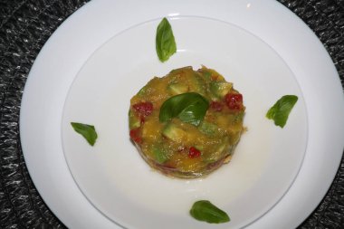 Ceviche 'ye yakın, vegan yemeği, mango, domates, avokado, chili, limon karışımı, beyaz bir tabakta servis edilir.,