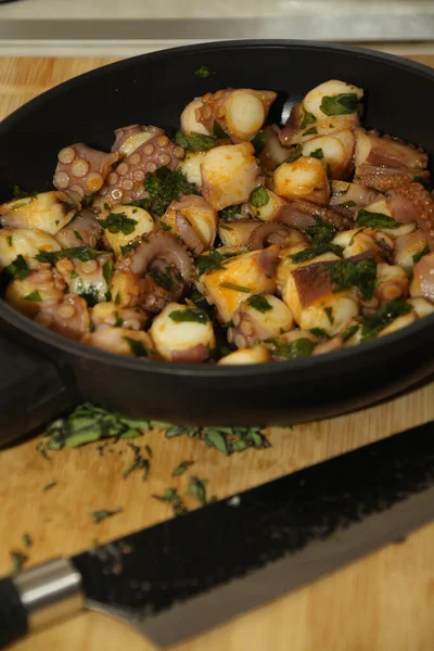 close up of a pan with seafood, tubes, squid, herbs,