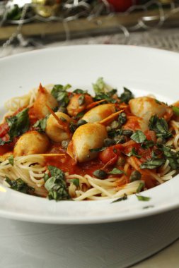 Pekorino, ekmek kırıntıları, kapari, makarna, domates sosu, fesleğen, sarımsak, maydanoz ve İtalyan yemeği ile doldurulmuş kalamar tüpleri.,