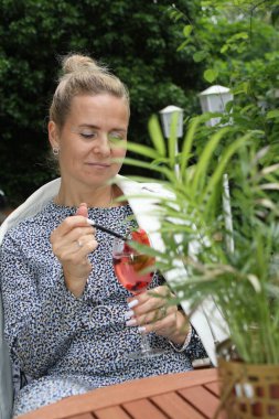 Elinde bir bardak aperolle çekici bir kadın.