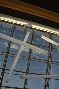 Cam ve çelikten yapılmış grafik çatı yapısı, ışıkla dolu.