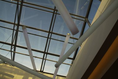 Cam ve çelikten yapılmış grafik çatı yapısı, ışıkla dolu.