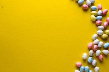 Sarı arka planda renkli paskalya yumurtaları. Kopyalama alanı olan üst görünüm