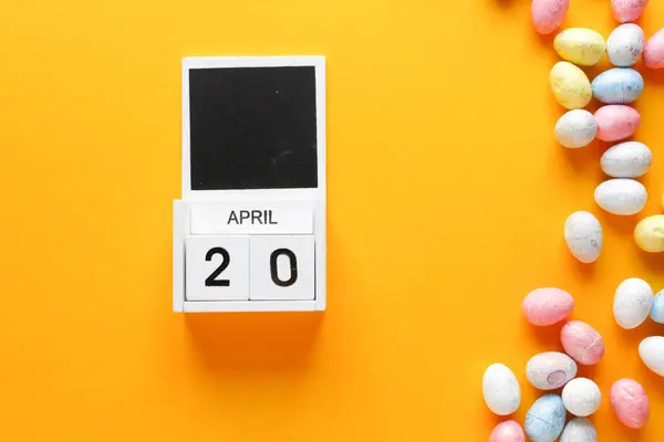 Renkli şekerler ve turuncu arka planda takvim. Üst görünüm.