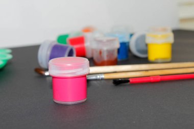 Siyah arkaplanda fırça ve boya, yakın plan.