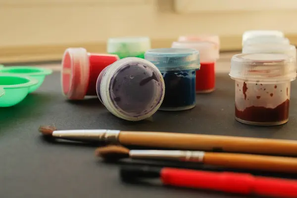 Siyah arkaplanda fırça ve boya, yakın plan.