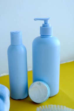 Sarı arka planda bir vücut bakımı şişesi var.