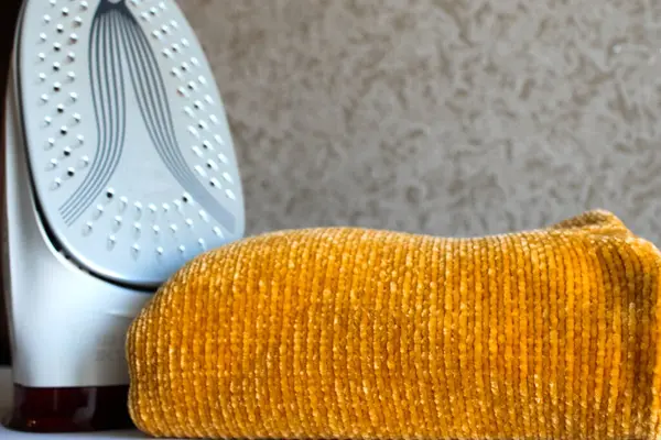 Ev hayatı. Demir ütülenmiş elbiselerin yanında durur.