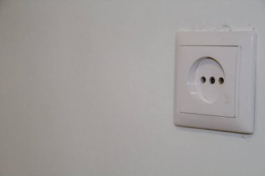 Beyaz bir duvarda beyaz elektrik prizi