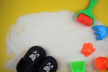 Kum kalıpları ve plaj terlikleriyle kumlu arka plan. Tatil ve sahil konsepti