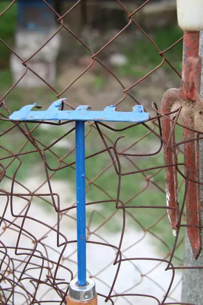Çitte asılı mavi tırmık. Bahçe ve sebze bahçesi konsepti..