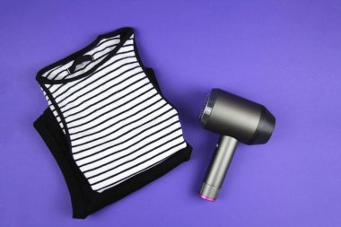 Giysiler için bakım ve ilgi kavramı. İlaç makinesi mor bir arka planda yatıyor. Üst görünüm.