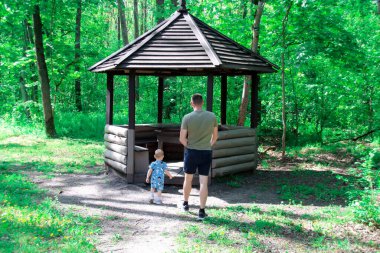 Baba ve oğul ormanda yürüyor.