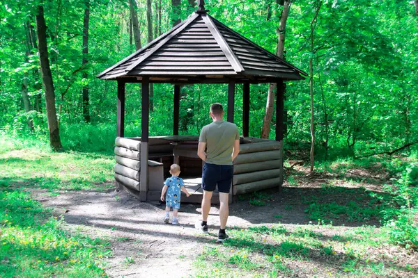 Baba ve oğul ormanda yürüyor.