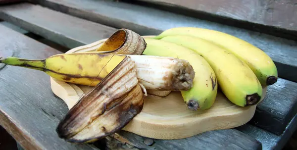 Ahşap tepside muzlar var. İçlerinden biri öne çıkıyor, çünkü olgunlaşmış..