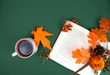 Bir fincan kahve ve akçaağaç yaprağıyla sonbahar kompozisyonu.