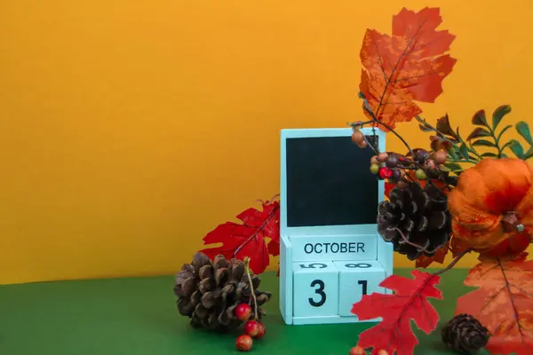 Çam kozalakları ve yapraklar bir takvimi tarihle süsler.