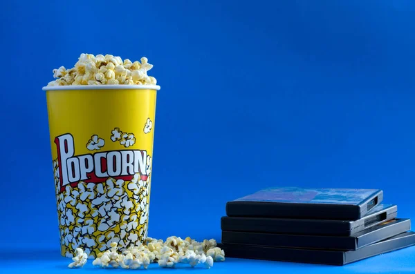 Yellow Popcorn Box with CD Movies on Blue Background Horizontal