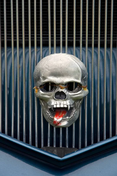 怖いです人間の頭蓋骨と赤い舌車のフロントグリル垂直 — ストック写真