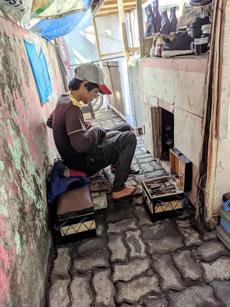 Sırt çantası ve kahve çantası olan şapkalı bir adam.