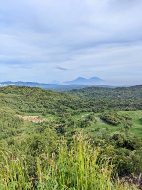 Dağları ve mavi gökyüzü olan güzel bir manzara.