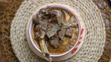 Pallu basa adı verilen tipik bir Sulawesi yiyeceği, arka plan olarak Endonezya takımadası teması ile fotoğraflanmıştır.