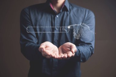 El internetten arama motoruna tıklıyor. Elinde tutan adam.