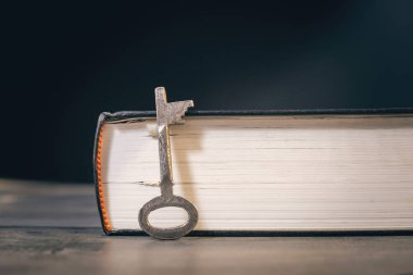 Metal anahtar ve kitap ahşap masada.