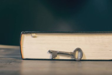 Metal anahtar ve kitap ahşap masada.