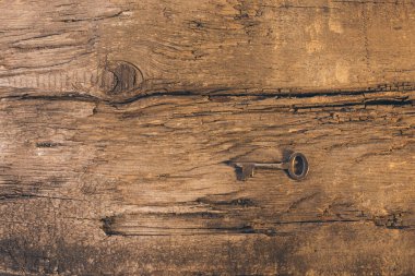 Eski ahşap bir masada metal bir anahtar.