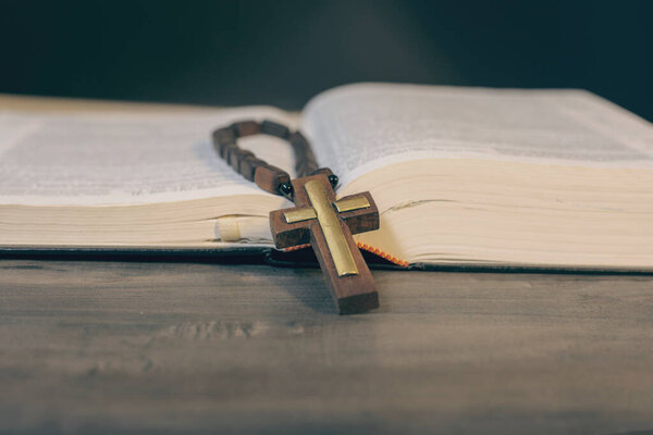 Book and cross on a wooden table